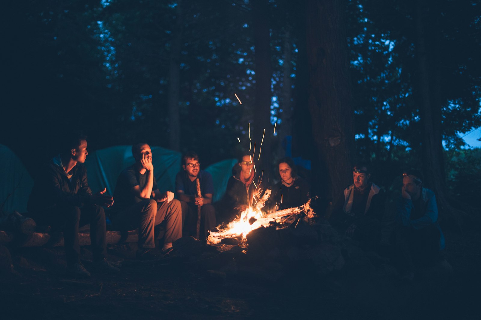 Familie kocht gemeinsam am Lagerfeuer